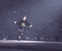 a man in a black hoodie with a yellow star on it is running on a stage