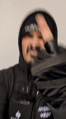 a blurry picture of a person wearing a hoodie and gloves with the word ness written on it