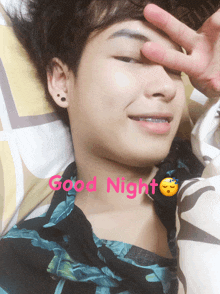 a young man laying on a bed with the word good night written on his face