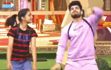 a man and a woman are standing next to each other and dancing in a room .