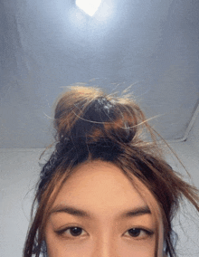 a close up of a woman 's face with a bun