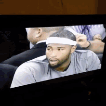 a man wearing a white headband is sitting in a chair