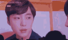 a close up of a young man 's face looking at another man .