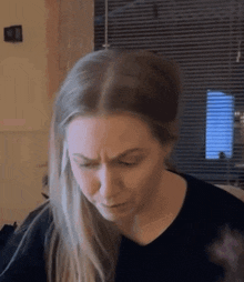 a woman in a black shirt is making a funny face