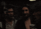 a man and a woman are sitting in a dark room and the woman is screaming