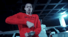 a man wearing a red sweater that says milano is dancing