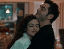 a man and a woman are hugging each other with their eyes closed