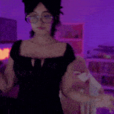 a woman in a black dress giving a thumbs up with a purple background