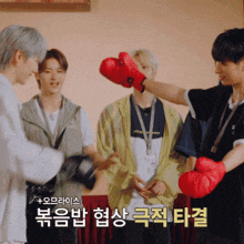 a group of young men wearing red boxing gloves with korean writing
