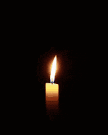 a candle is lit in the dark with a blue candle sticking out of it