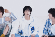 a boy with a name tag that says ' a ' on it is sitting next to two other boys