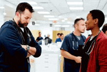 a man and a woman are standing next to each other in a hospital room .