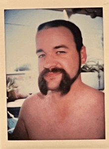 a shirtless man with a beard and mustache