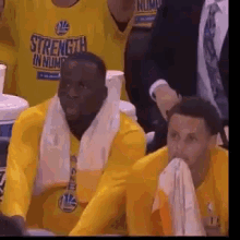 two basketball players wearing yellow shirts that say strength in number