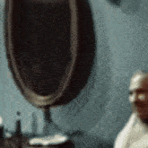a blurry picture of a man shaving with a mirror behind him