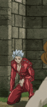 a man in a red suit is kneeling down in front of a stone wall