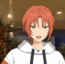 a girl with red hair and green eyes is wearing a white hoodie and making a funny face .