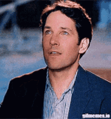 a man in a suit and striped shirt is looking up at the sky .