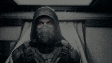a man wearing a gas mask and a hood is looking at the camera