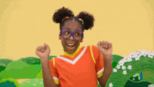a young girl wearing glasses and a red shirt is dancing in a field .