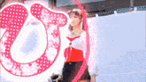 a woman is standing in front of a large pink letter o