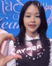 a woman is holding a sign that says carmen