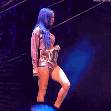 a woman with blue hair wearing a wrestling belt