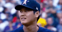 a close up of a baseball player wearing a hat and looking at the camera .