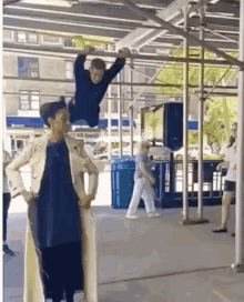 a woman is standing next to a boy who is hanging from a bar .