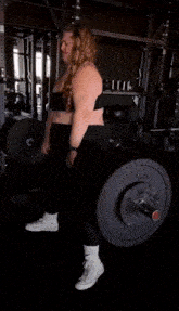 a woman is lifting a barbell with a plate that says 16 kg on it