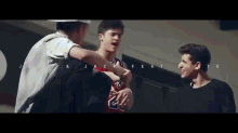 a man wearing a jersey with the number 23 on it talks to two other men