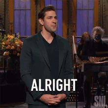 a man in a suit says " alright " on a snl show