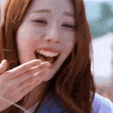 a close up of a woman eating a piece of food