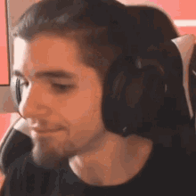 a man wearing headphones is sitting in a chair and looking at the camera .