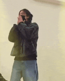 a person wearing a mask is taking a picture with a cell phone .