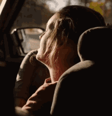 a woman sitting in a car looking out the window