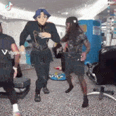 a group of people are dancing in a room with a blue box in the background .