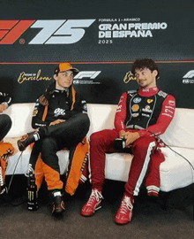 a group of men sit on a couch in front of a sign that says 75 gran premio de espana