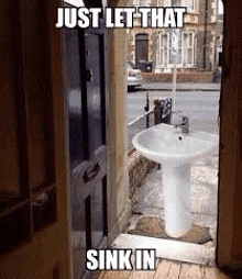 a sink is sitting outside of a doorway next to a building .