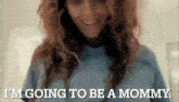 a woman in a blue shirt is going to be a mommy