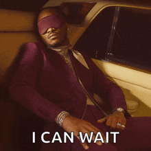 a man in a suit is sitting in the back seat of a car with the words " i can wait " on the bottom
