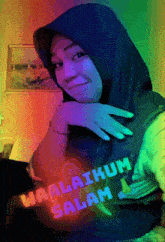 a woman wearing a blue hijab and a shirt that says waalaikum salam