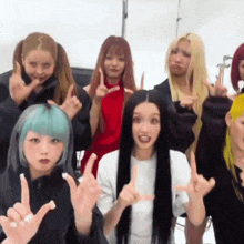a group of young women are posing for a picture and making funny faces with their hands