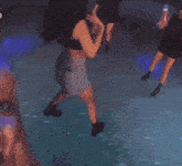 a woman in a black crop top and shorts is dancing on a stage