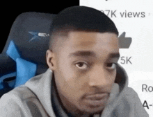 a man is sitting in a chair and making a funny face while looking at the camera .