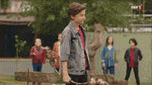 a boy with a bow and arrow stands in front of a group of children with trt 1 written on the bottom