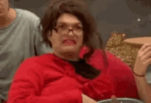 a close up of a person with glasses making a funny face with their mouth open .