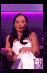 a woman in a white strapless dress is sitting on a couch