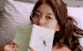 a woman wearing glasses is reading a book .