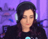 a woman wearing headphones is sitting in front of a purple background .